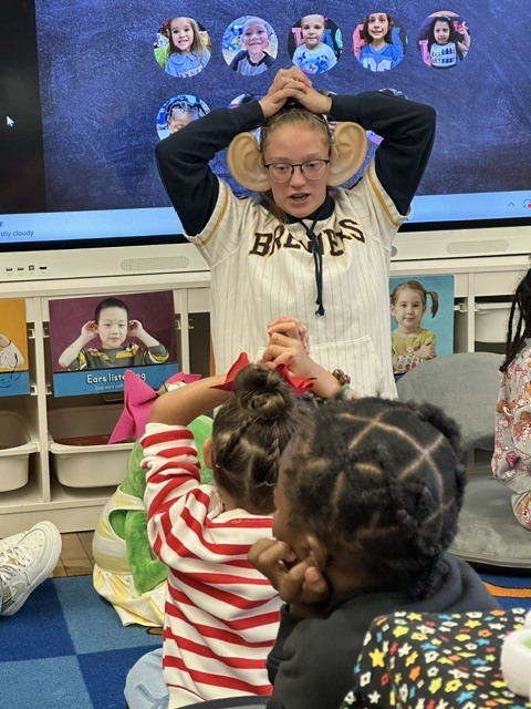 PreK teacher deep breathing with students.