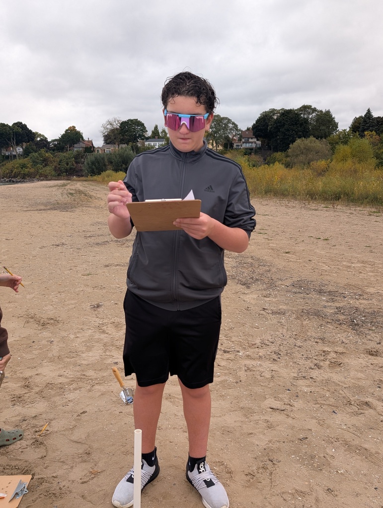 A student keeping track of the dig site findings with a clipboard.