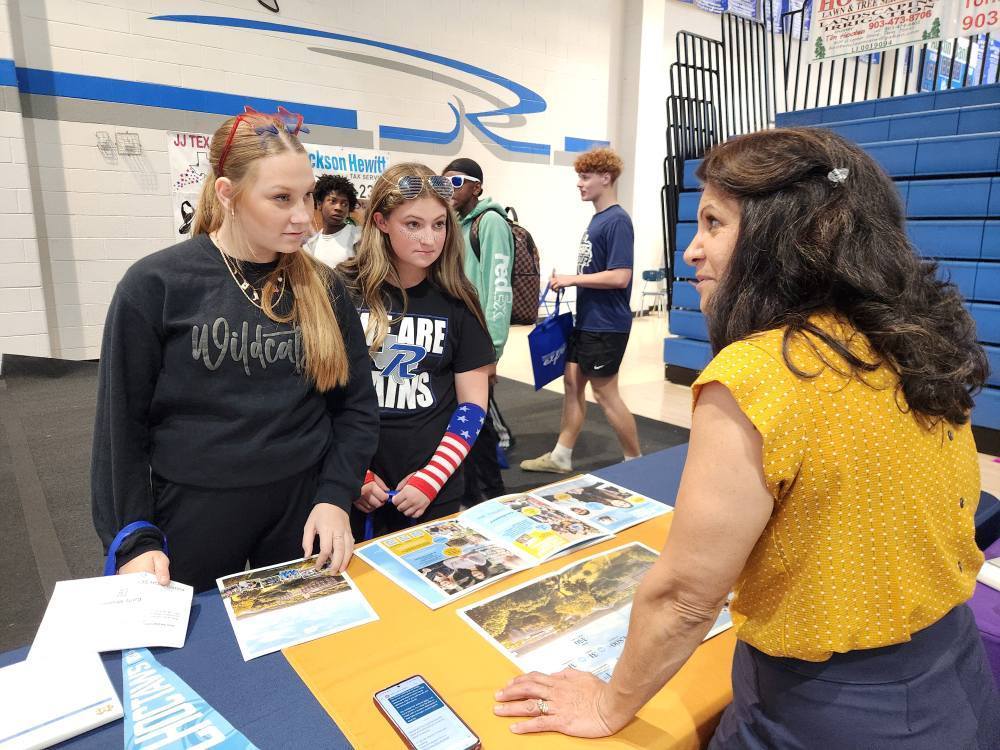 Two high school girls are engaged in conversation during the college and career day