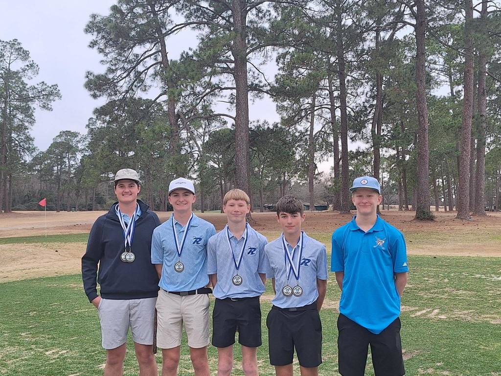 Rains Wildcat Golf Team lined up for a picture displaying their medals around their necks from a golf tournament.