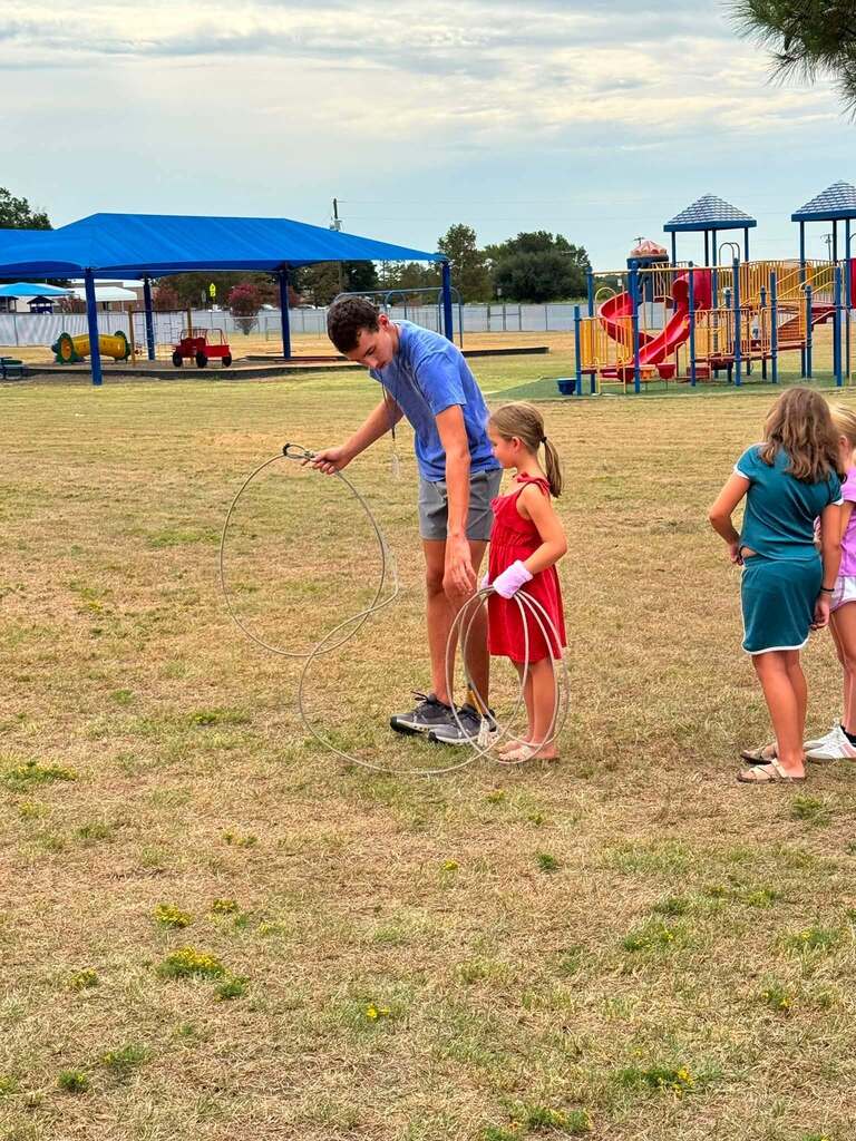 2nd Grade class roping dummy cows with the help of FFA Officers.