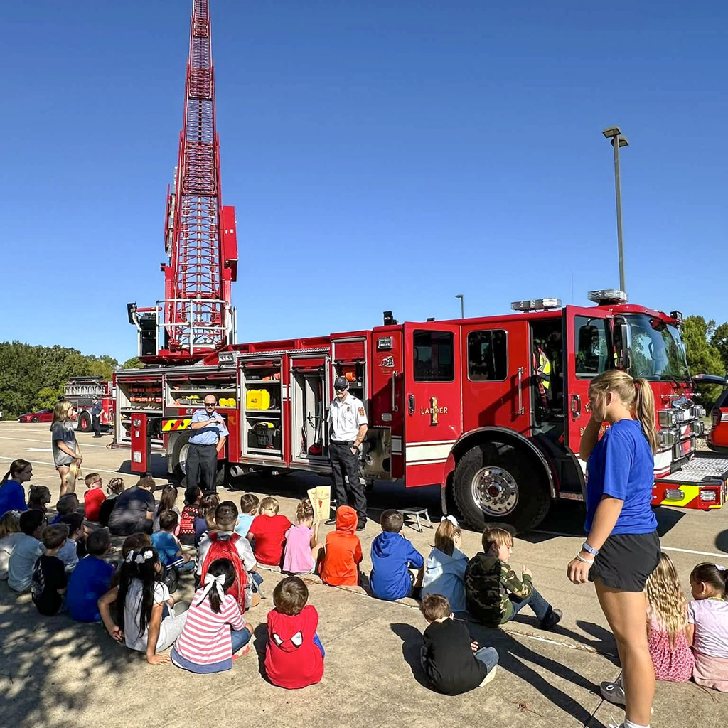 Elementary kids learning fire safety from fire fighters