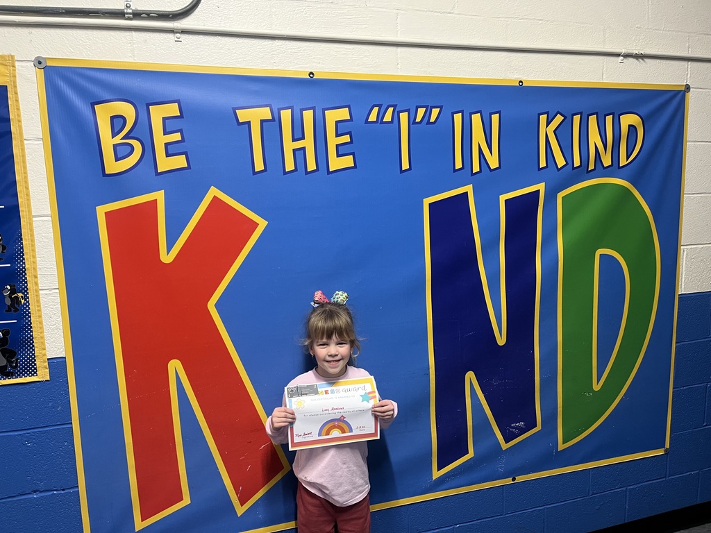 Student holding kind award