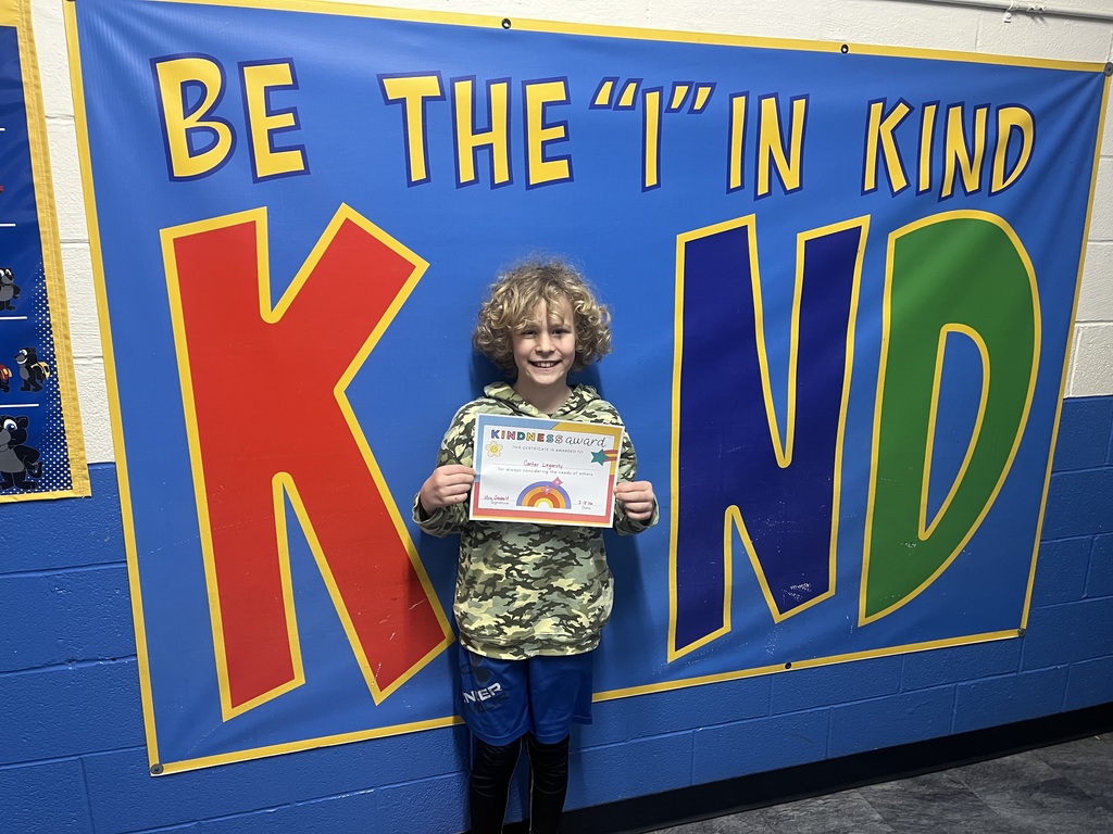 Student holding kind award