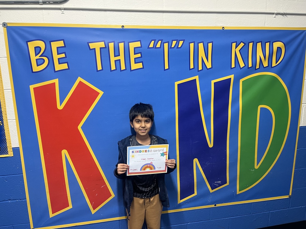 Student holding kind award