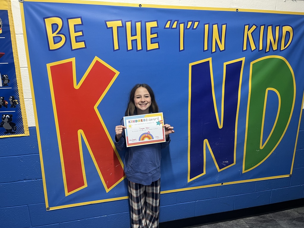 Student holding kind award