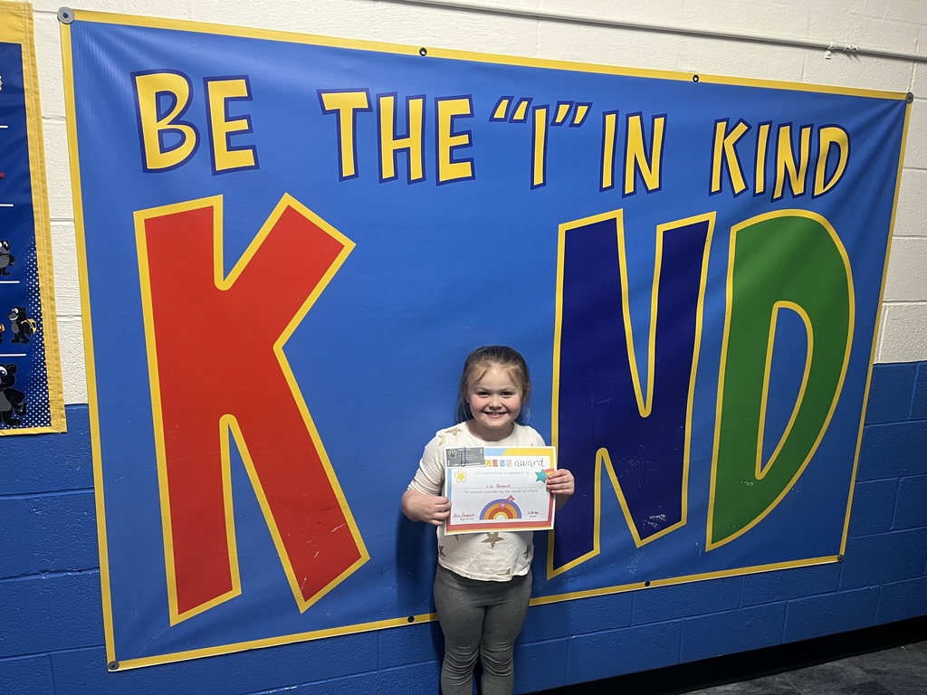 Student holding kind award