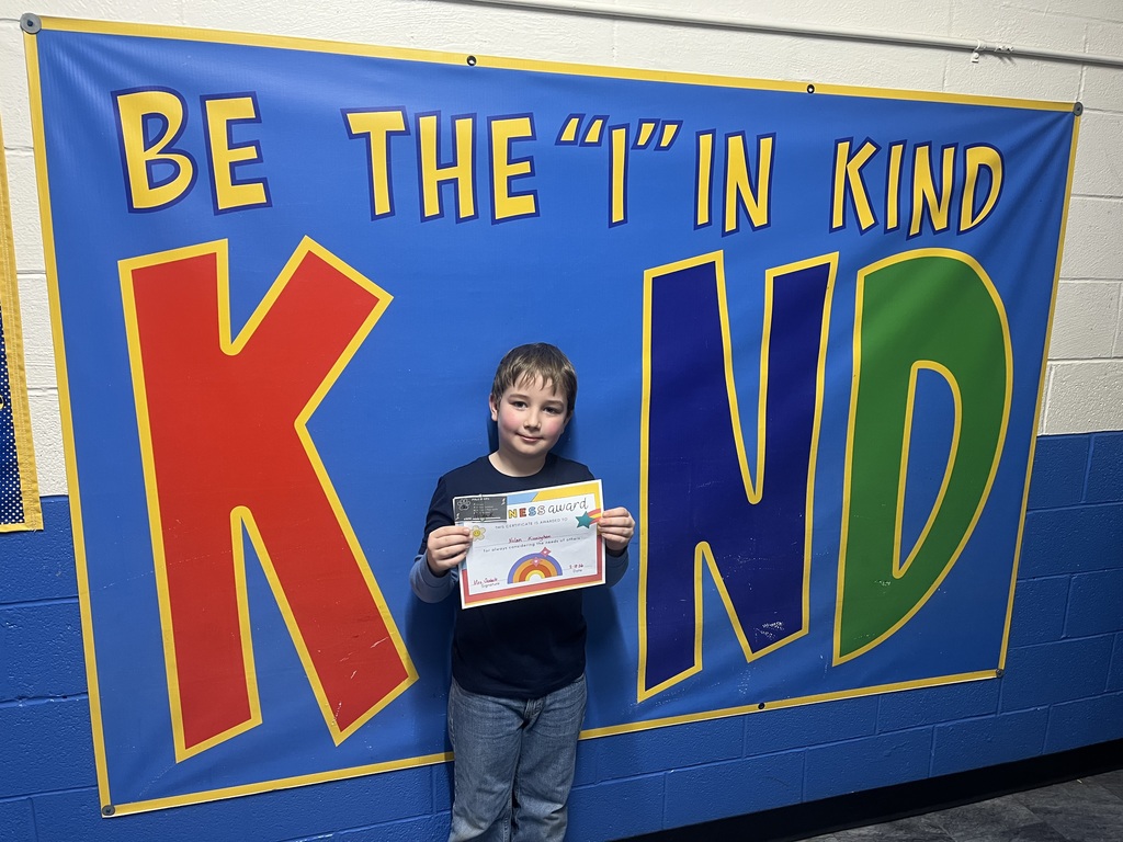 Student holding kind award