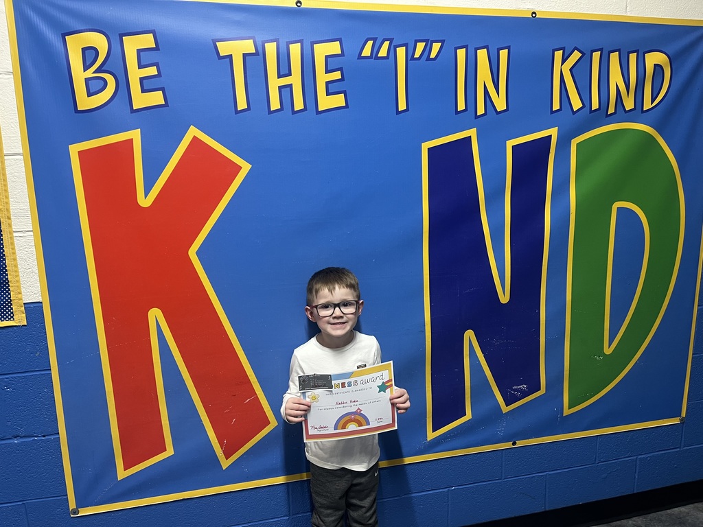 Student holding kind award