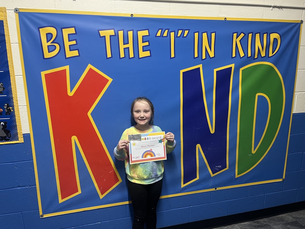 Student holding kind award