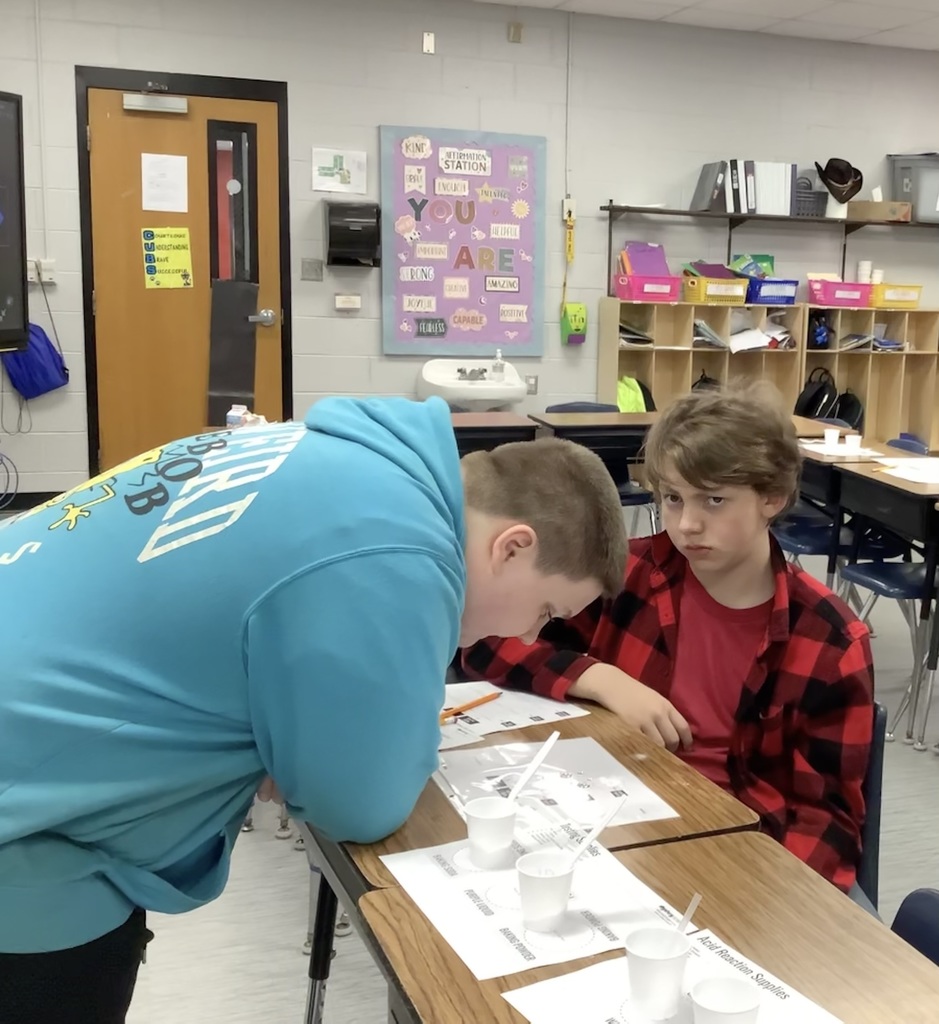 A student is leaned over the desk looking at chemical reactions.