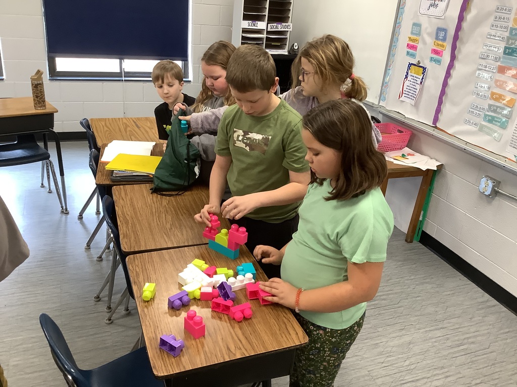 Students are building with blocks at their desks.