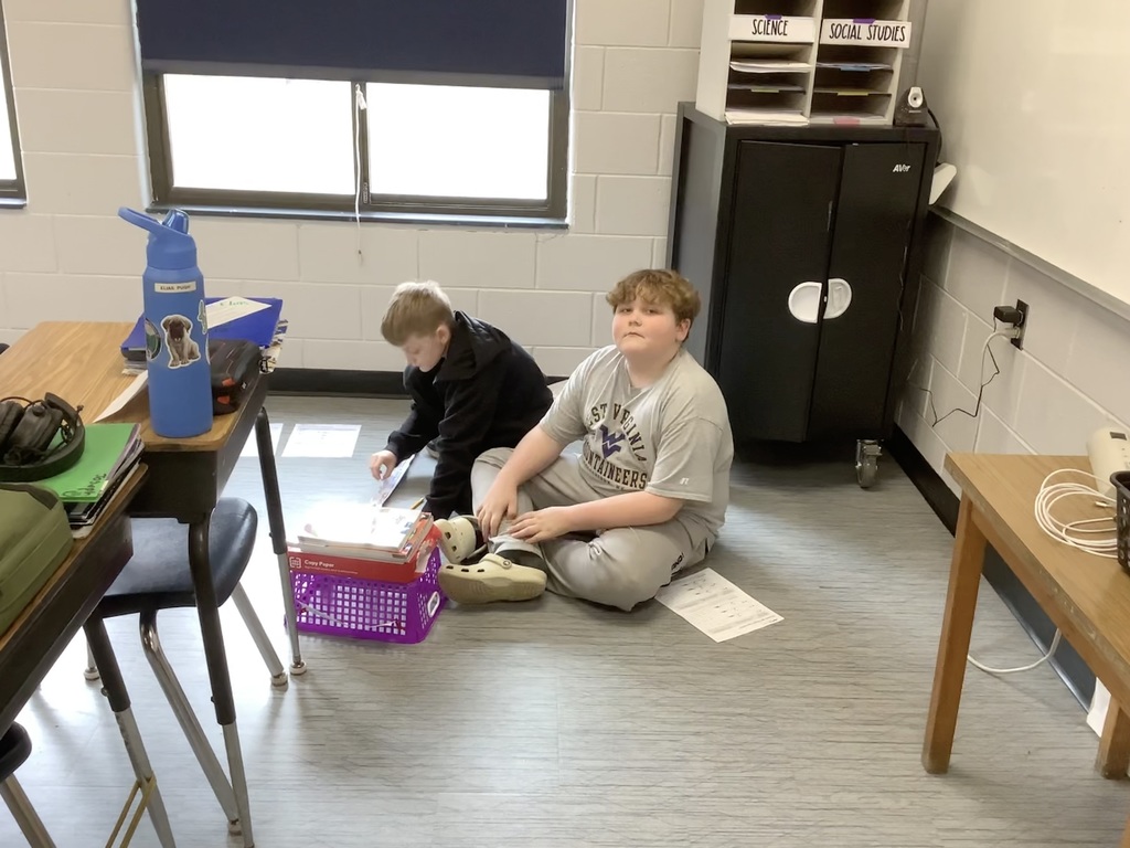 4th grade students are sitting in the floor working on energy and energy transfer.