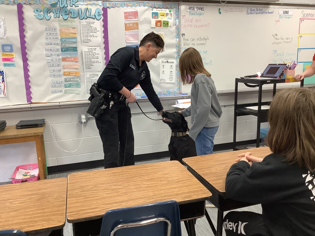 5th grade student is petting police dog.