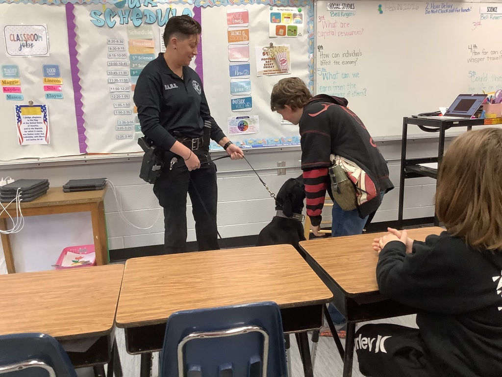 5th grade student is petting police dog.