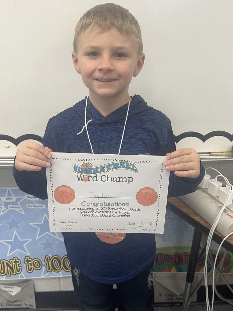 Student is holding his basketball certificate and smiling. 