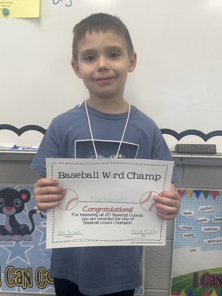 Student is holding his baseball word certificate and smiling.