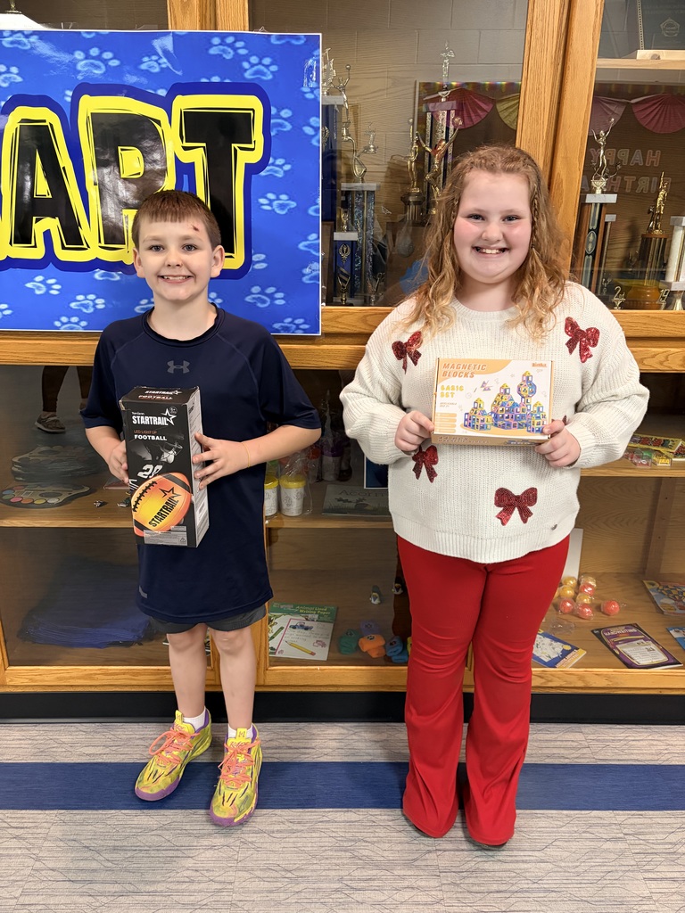 Cub of the month for January. Two students, one boy and one girl, is holding their prizes for winning cub of the month. 