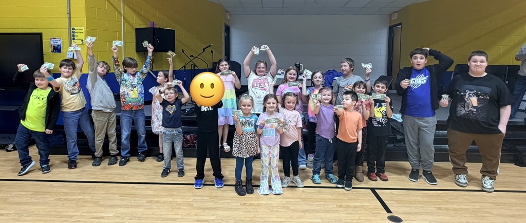 Dance off winners holding their dollar bills and smiling. 