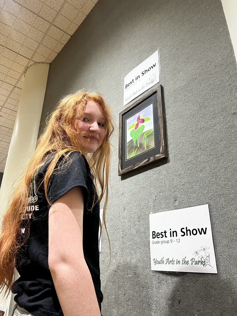 Ella hanging her work in the gallery