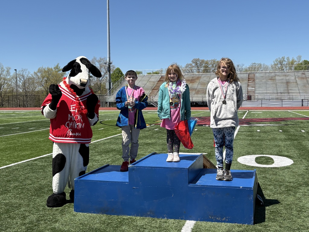 Kevin, Kaelynn, and Adelynn receiving their metals at the No Limits Invitational with the Chick-fil-A Cow.  