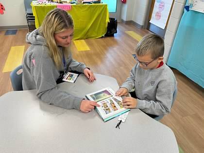 A mother and son reading a book together.  The book is a graphic novel. 