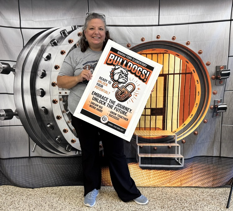 Mrs. Wood standing with a sign that says Marsh Fork Bulldogs, Ready to unlock your potential? Embrace the Journey, Unlock the Future! Dream Big! Work Hard! Grow Together! Succeed!