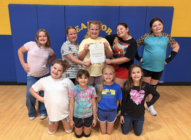 cheerleaders with check from governor for new uniforms.