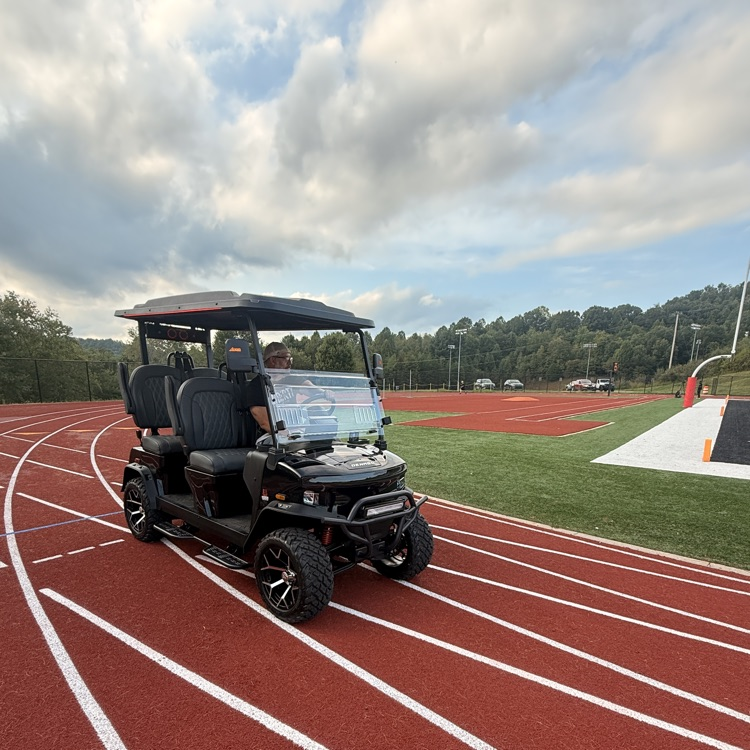 golf cart on track with a partly cloudy sky