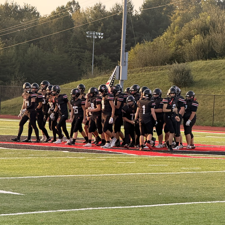 football team huddling on field