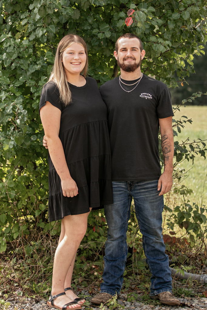 A man and a woman stand next to each other. They are posing for a picture.