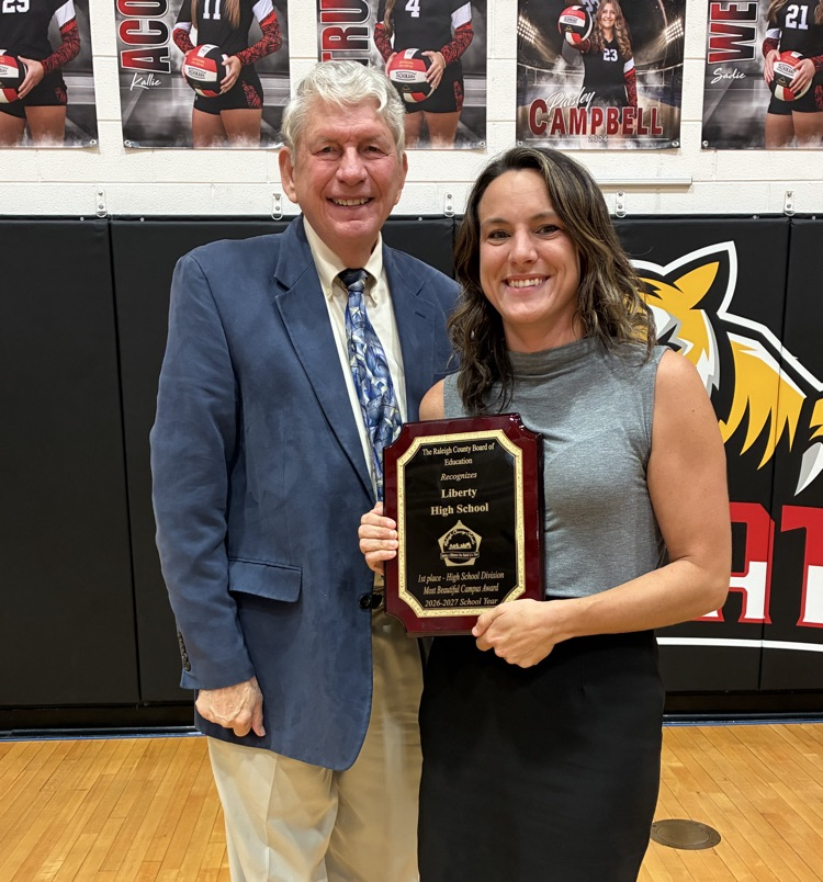 principal Jamie Bailey from liberty high school accepting the award for most beautiful campus from board member of Larry Ford