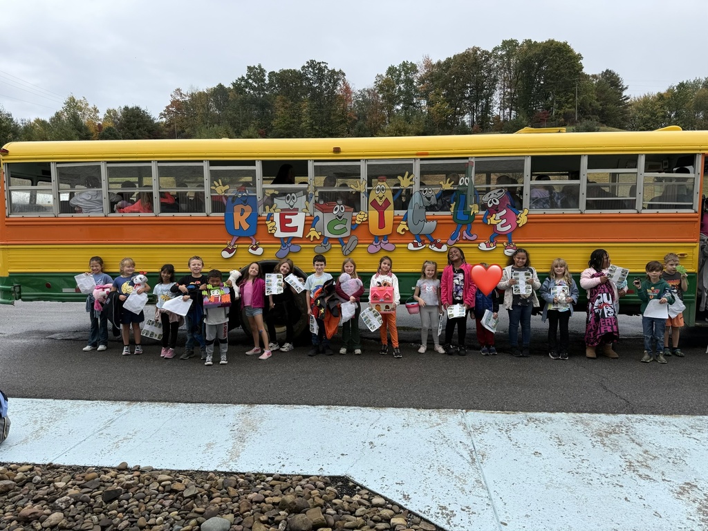 Children in costumes standing in front of a colorful bus with letters R E G U on it.