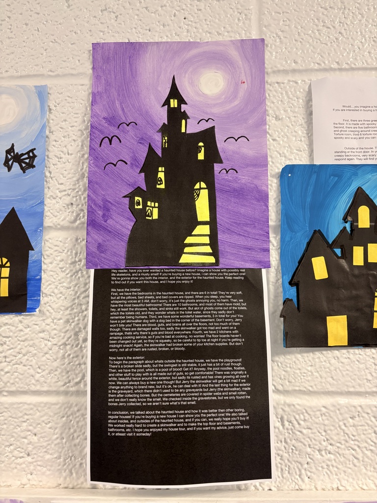 Three paintings of houses with windows and doors hang on a white wall. One painting has a moon.