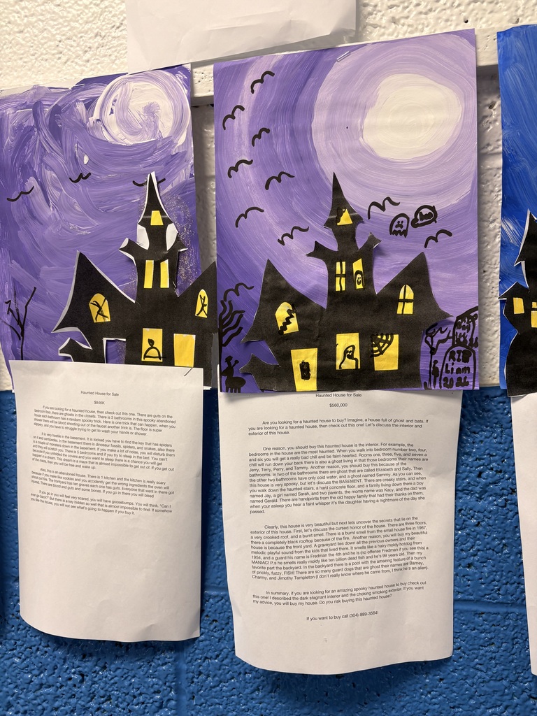 Three illustrated papers hang on blue wall. Paper in middle has black text. Papers on ends have black and yellow drawings of haunted houses.