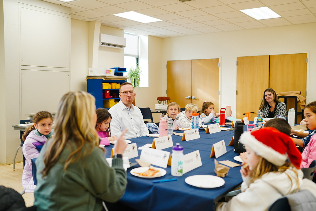 Group of students and staff around table.