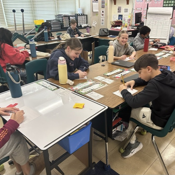 Students in 5Jo complete a postcard activity after listening to a read aloud for Read Across America!