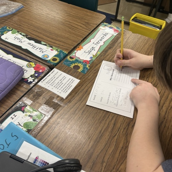 Students in 5Jo complete a postcard activity after listening to a read aloud for Read Across America!