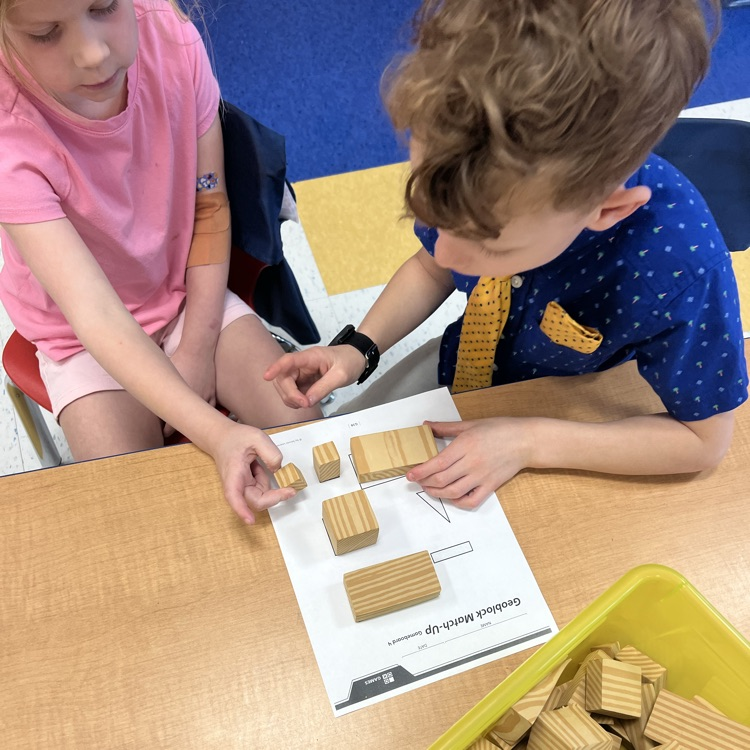 Kindergarten friends working together in partners to find matching faces with our geoblocks—teamwork and problem-solving in action!