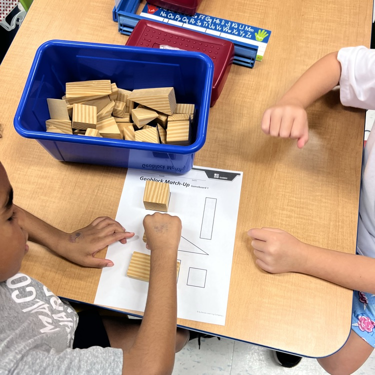 Kindergarten friends working together in partners to find matching faces with our geoblocks—teamwork and problem-solving in action!
