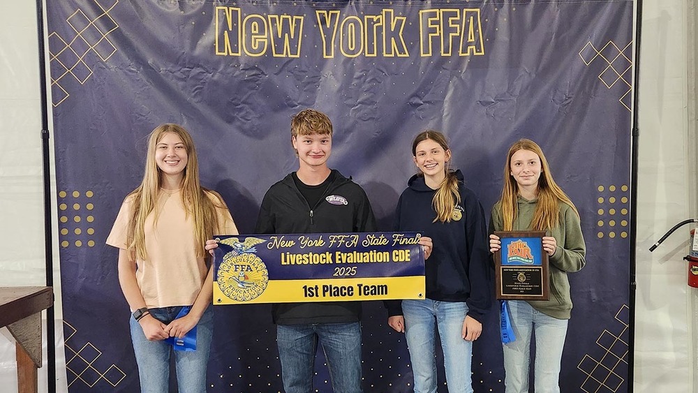 Four students hold their first place banner for Livestock Evaluation.