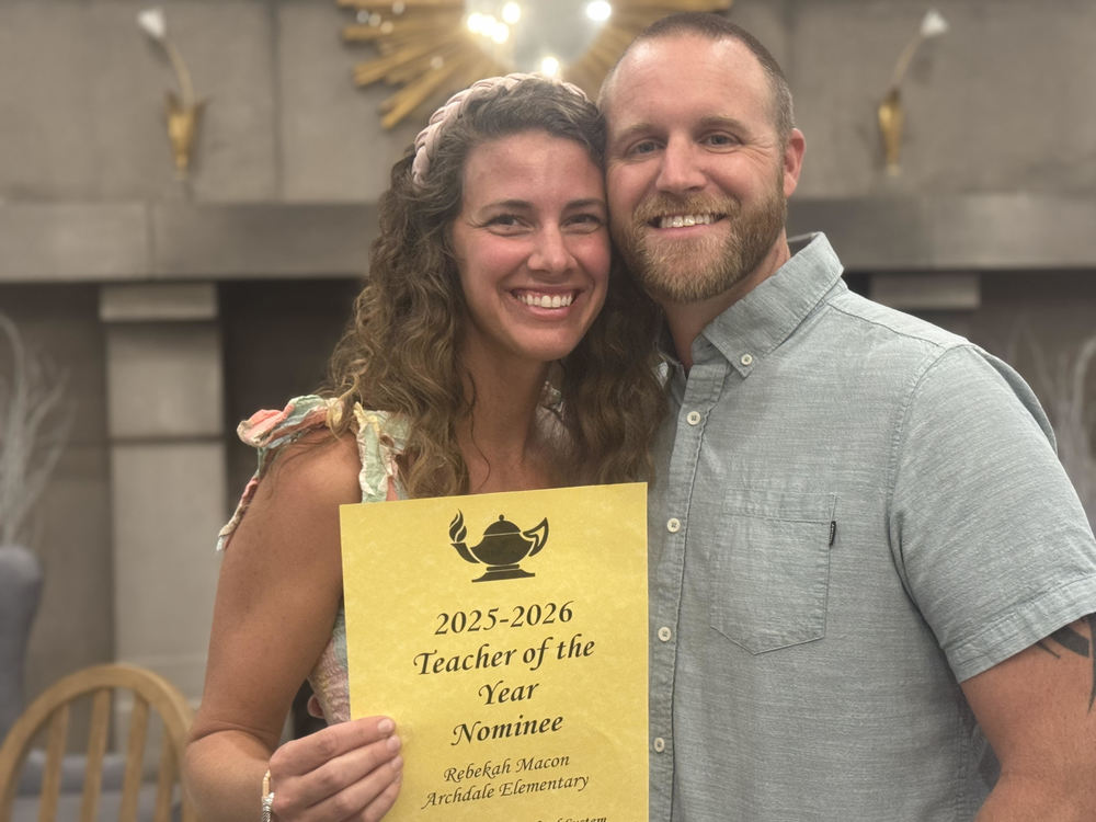 Photo of teacher (Mrs. Macon) holding a certificate that says 2025-2026 Teacher of the Year Nominee, Rebekah Macon, Archdale Elementary.