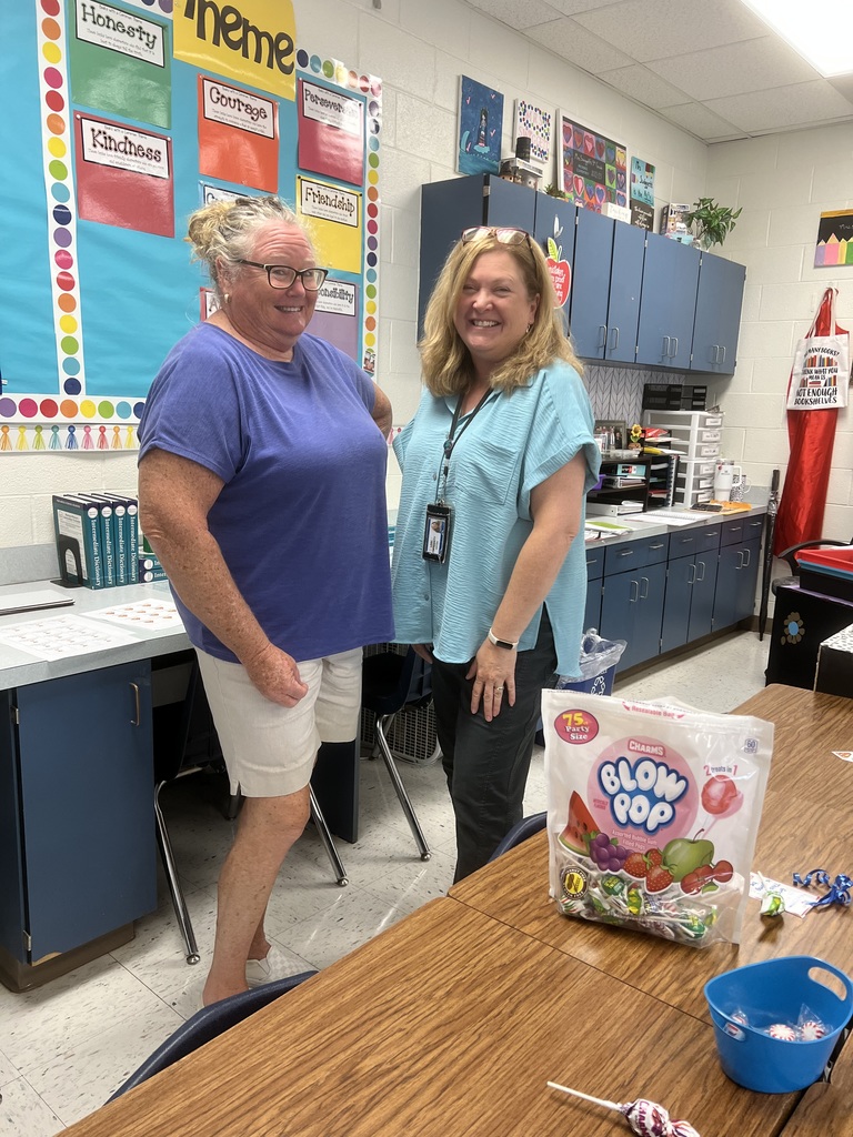 Teachers smiling, standing in a classroom