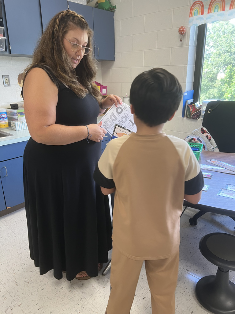 A teacher talking to a student in a classroom