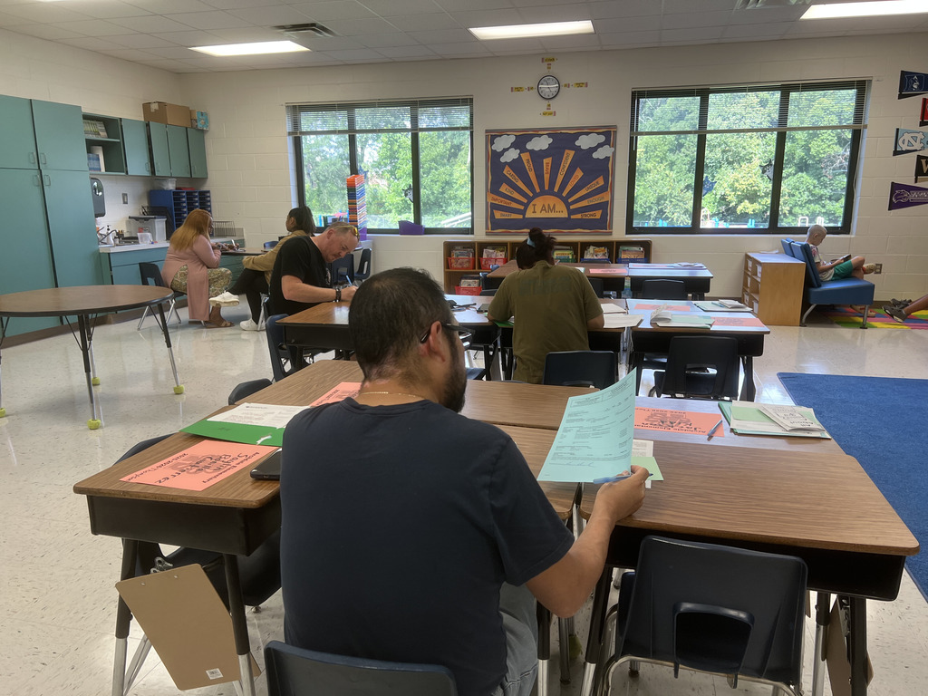 Parents in a classroom filling out forms
