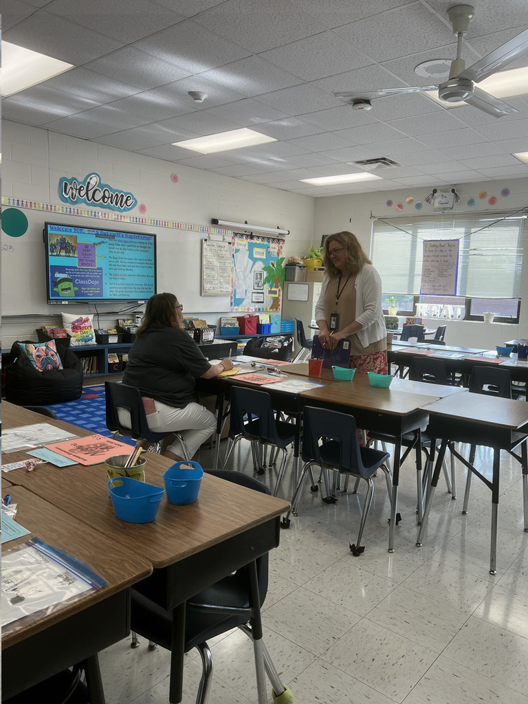A teacher talking to a parent in a classroom