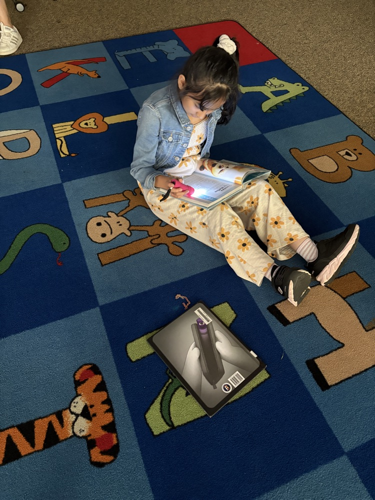 Children reading in a dark media center with flashlights