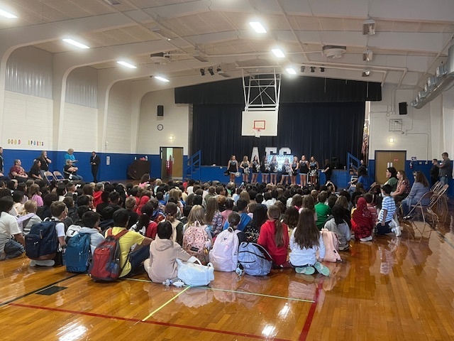 Students in a gymnasium for an assembly