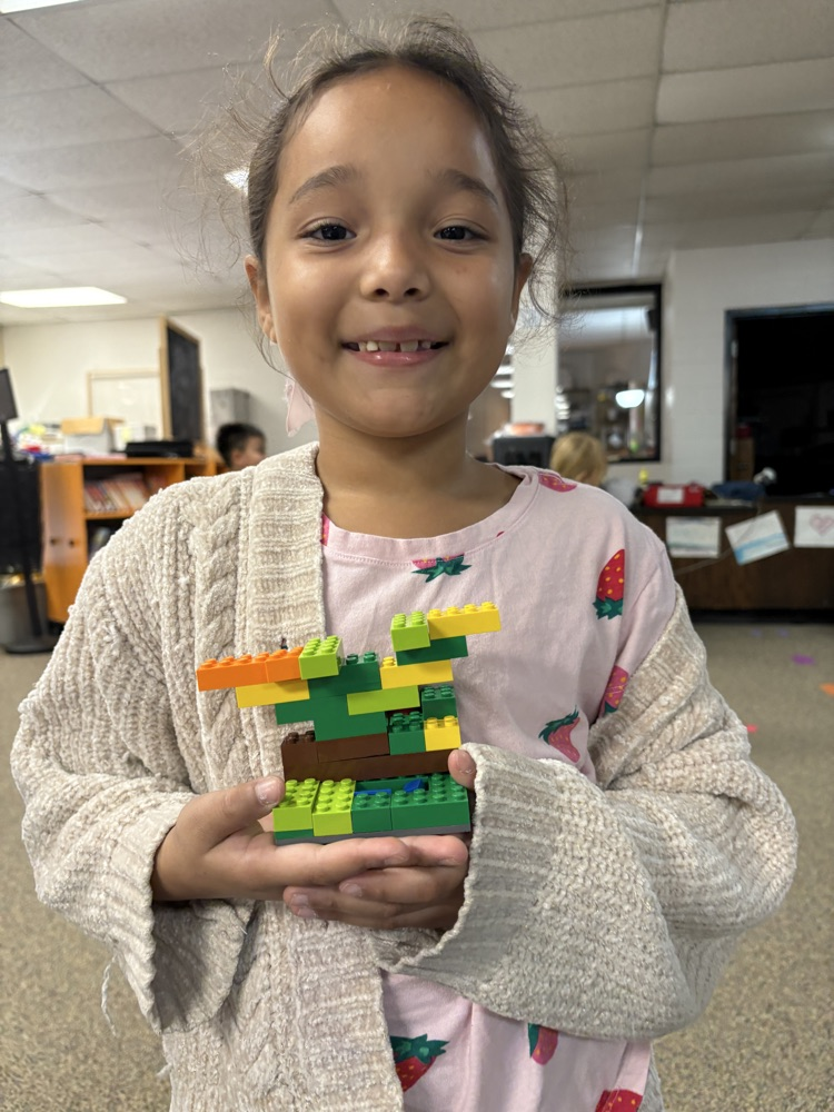 Student holding a Lego fall tree.