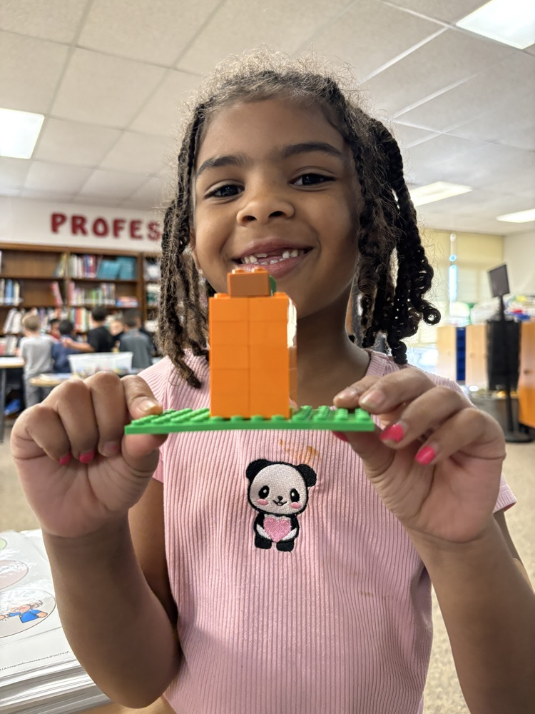 Student holding a Lego pumpkin 